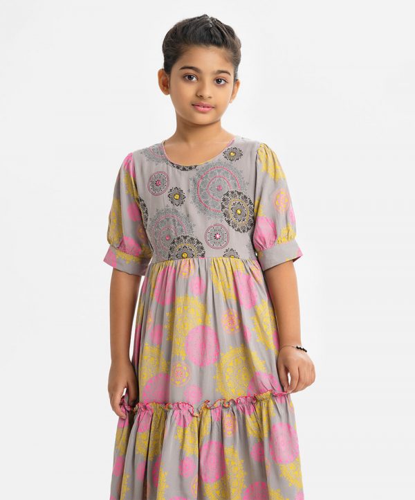 Kid girls printed flared style frock in viscose fabric. Puff sleeves, round neck. Embroidery at the front and tie-cord waist belt.