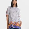Printed straight tunic in joom fabric. Mock neck, short sleeve and attach patch at the hemline.