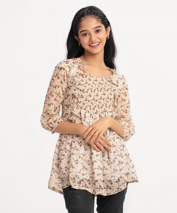 Teen girl tent-style woven top in georgette fabric. Square neck, bishop sleeved. Frill trims and smoky at the front.
