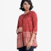 Short tunic with shrug in crepe fabric. Round neck, three-quarter sleeved. A button fastening at the front and embroidery at the hemline with crepe inner.