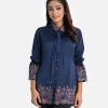 Women's shirt style tunic in crepe fabric. Classic collar, lantern sleeves. Front button opening and print detail at sleeves and hemline.