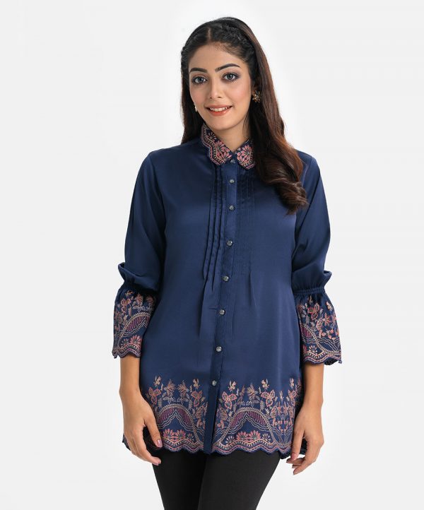 Women's shirt style tunic in crepe fabric. Classic collar, lantern sleeves. Front button opening and print detail at sleeves and hemline.