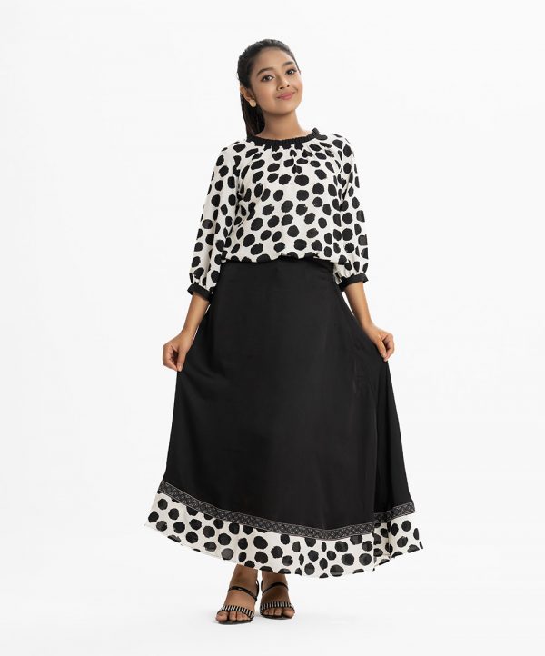 Printed skirt top set in georgette and crepe fabric. The ball printed balloon tops is round neck with pleats, puff-sleeve, and elasticated at the hemline. The skirt is elasticated at the waistline with zipper fly. Attached patch at the hemline.