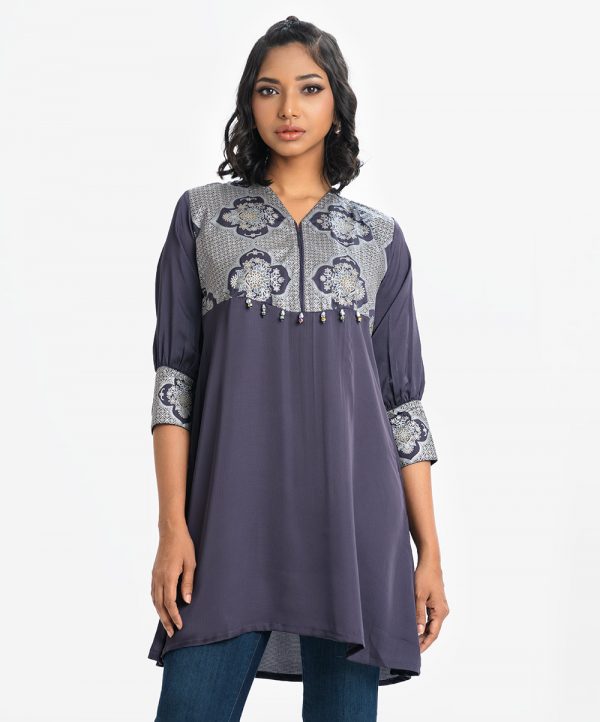 Women's A-line tunic in crepe fabric. V-neck, three-quarter sleeves. Beads attach at the front waistline.