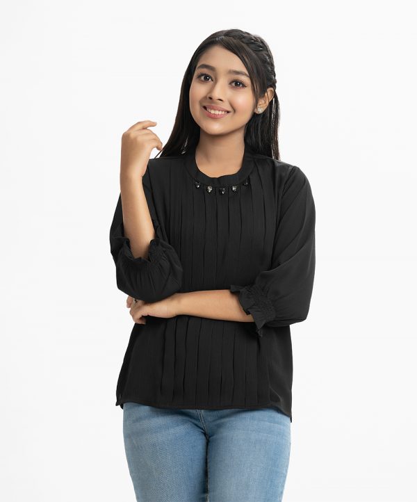 Teen girl's top in georgette fabric. Mock neck, long puff sleeved. Stone and pin-tuck at the front.