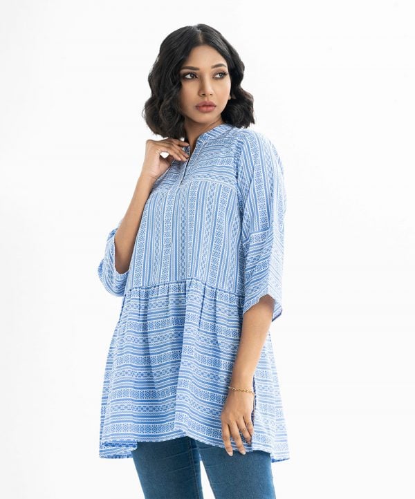 Printed tiered tunic in georgette fabric. Mandarin collar, bell-sleeved. Gathered at the waistline.