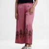Women's palazzo in satin fabric. Concealed elasticated waistline and floral print at the hemline.