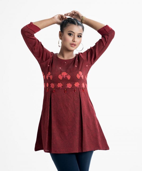Printed tent-style tunic in crepe fabric. Round neck, three-quarter sleeved with roll-up. Embroidery and box pleated at the front and attached decorative accessories.