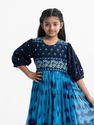 kid girls printed tent-style layered tunic in viscose and georgette fabric. puff-sleeves, round neck. Gathered at the waistline with a tassel tie.