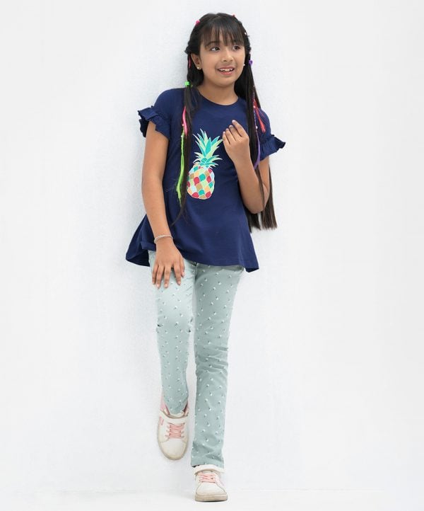 Round neck top in cotton single jersey fabric. Short ruffle sleeves. Pineapple print at top front.