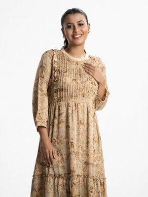 Women's frock style long tunic in floral printed zoom fabric. Mock neck, three-quarter sleeves. Frill trim with pin tuck at front. Gathered waistline with tie belt.