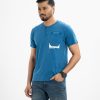 Men's henley T-shirt in cotton single jersey fabric. Rounded scoop neckline with front button fastening and short sleeves. Single chest pocket with print detail.