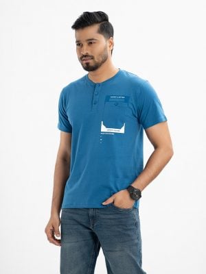 Men's henley T-shirt in cotton single jersey fabric. Rounded scoop neckline with front button fastening and short sleeves. Single chest pocket with print detail.