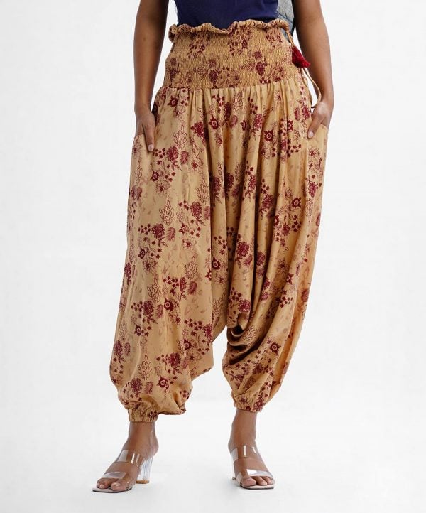 Women's floral printed harem pants in viscose fabric. Wide smocked waistline for a better fit. Pocket at sides.