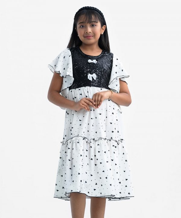 Kid girls tiered pattern frock in georgette fabric. Round neck, butterfly sleeved. Kachupi and decorative work at the front.