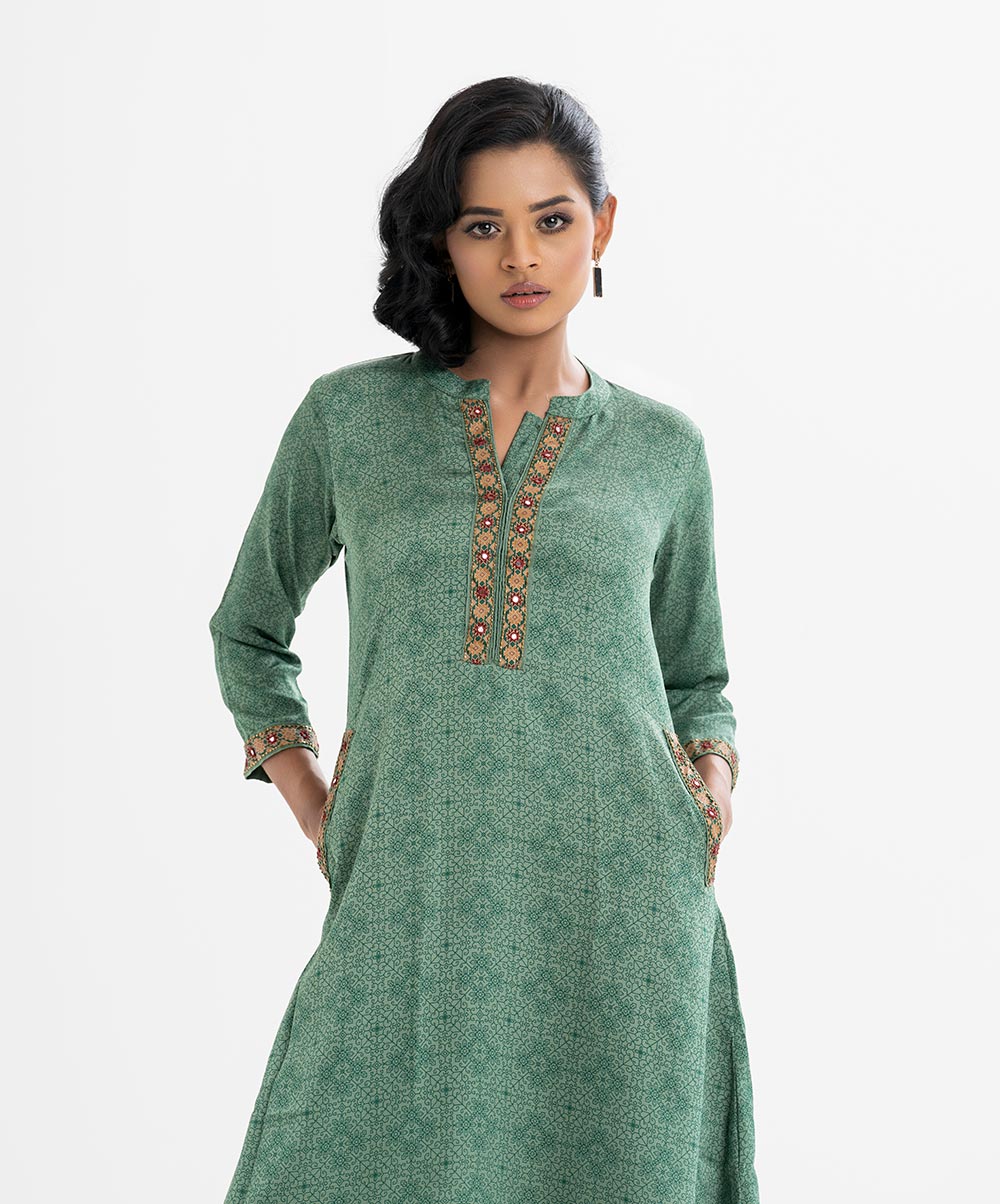 Women's A-line printed tunic in crepe fabric. Stand collar, long-sleeved. Karchupi at the placket, and two side pockets. Women's A-line printed tunic in crepe fabric. Stand collar, long-sleeved. Karchupi at the placket, and two side pockets.