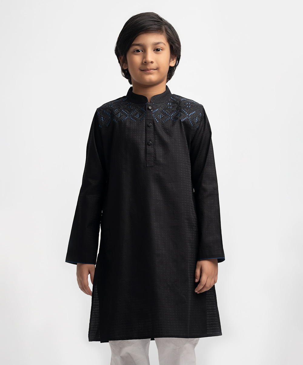 Kid boy's panjabi in cotton jacquard fabric. Mandarin collar & full sleeves. Embroidery at front & inseam pockets. Black Cotton Jacquard Panjabi