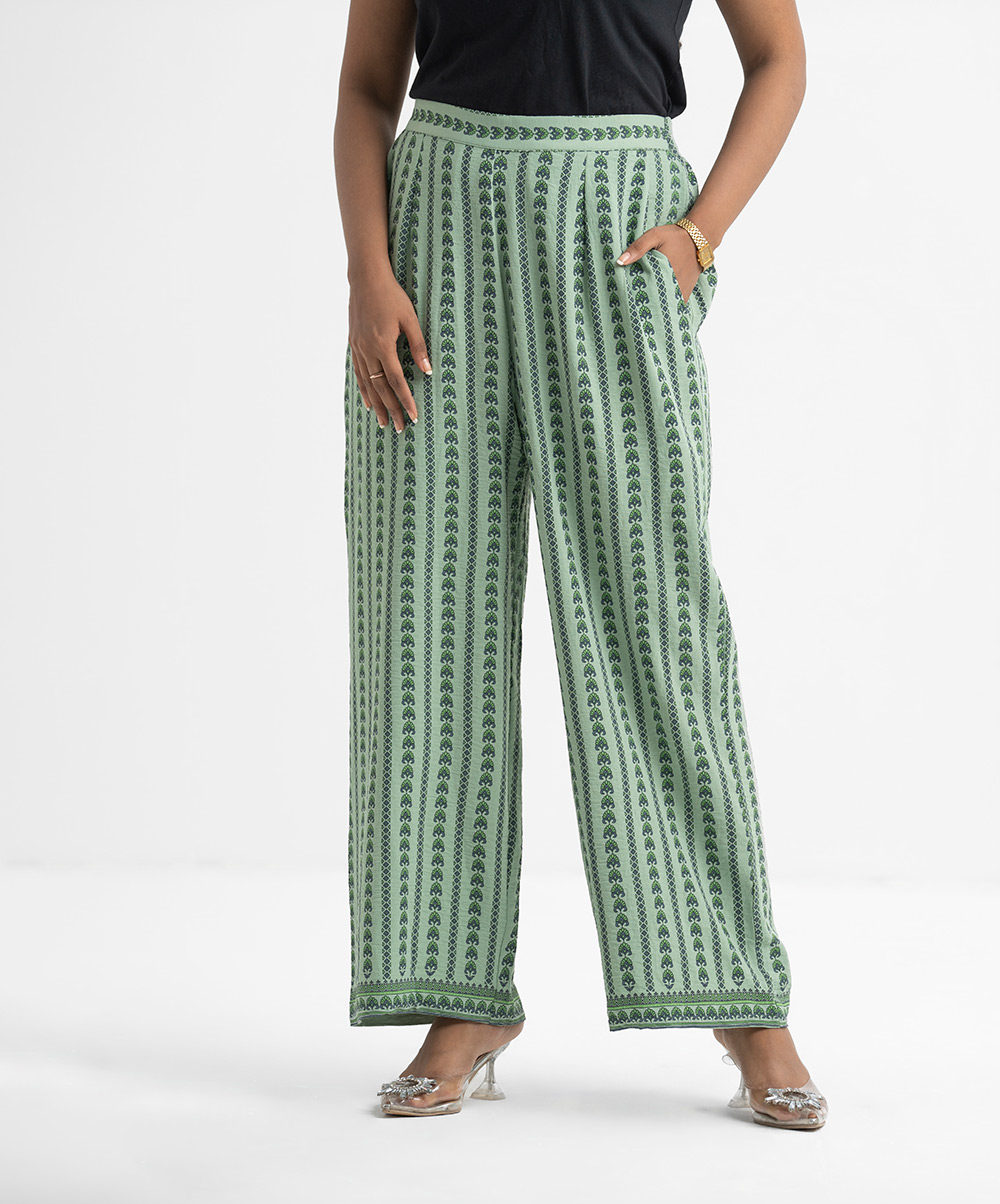 Women's printed pant style palazzo in stretchable georgette fabric. Concealed elasticated waistline with inseam pockets. Green Stretchable Georgette Palazzo