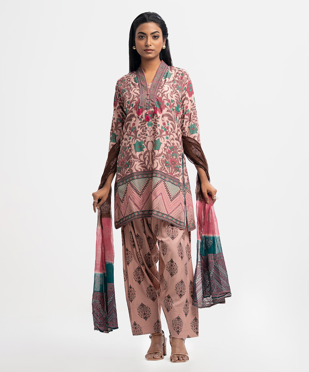 All over printed Salwar Kameez in blended cotton fabric. V-neck, three-quarter sleeves and karchupi at the front of kameez. Chiffon dupatta with wide hem classic pajama. Peach Cotton Straight Salwar Kameez
