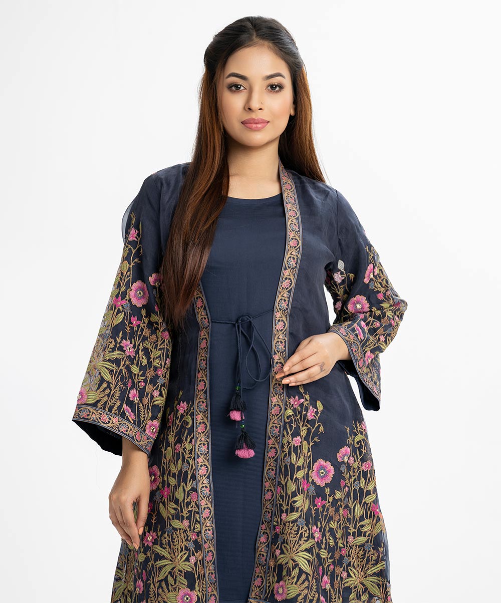 Exclusive shrug style tunic from Nargisus by Le Reve in muslin fabric with crepe lining. High collar, full bell sleeves, tassel tie, patch and karchupi at the front of shrug. Blue Muslin Shrug Style Tunic