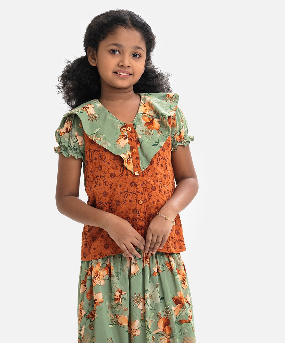 Soft and layered V-neck viscose top with puff sleeves. Paired with a smocked-waist skirt. Green Georgette Ghagra Choli